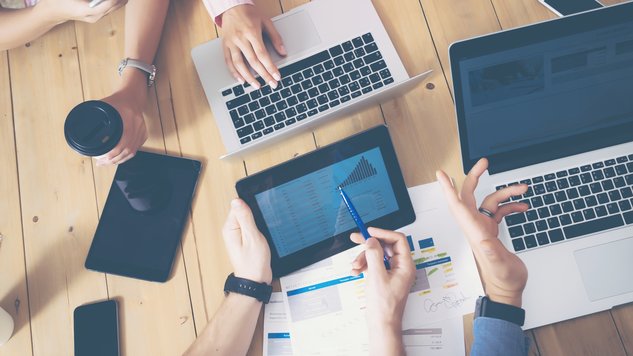 Generische Büro Szene Generisches Büro, mehrere Hände die über einen Tisch greifen Laptops und Tablets auf dem tisch