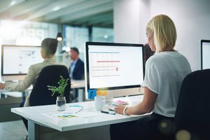 Generische Officeszene: Frau sitzt vor Bildschirm